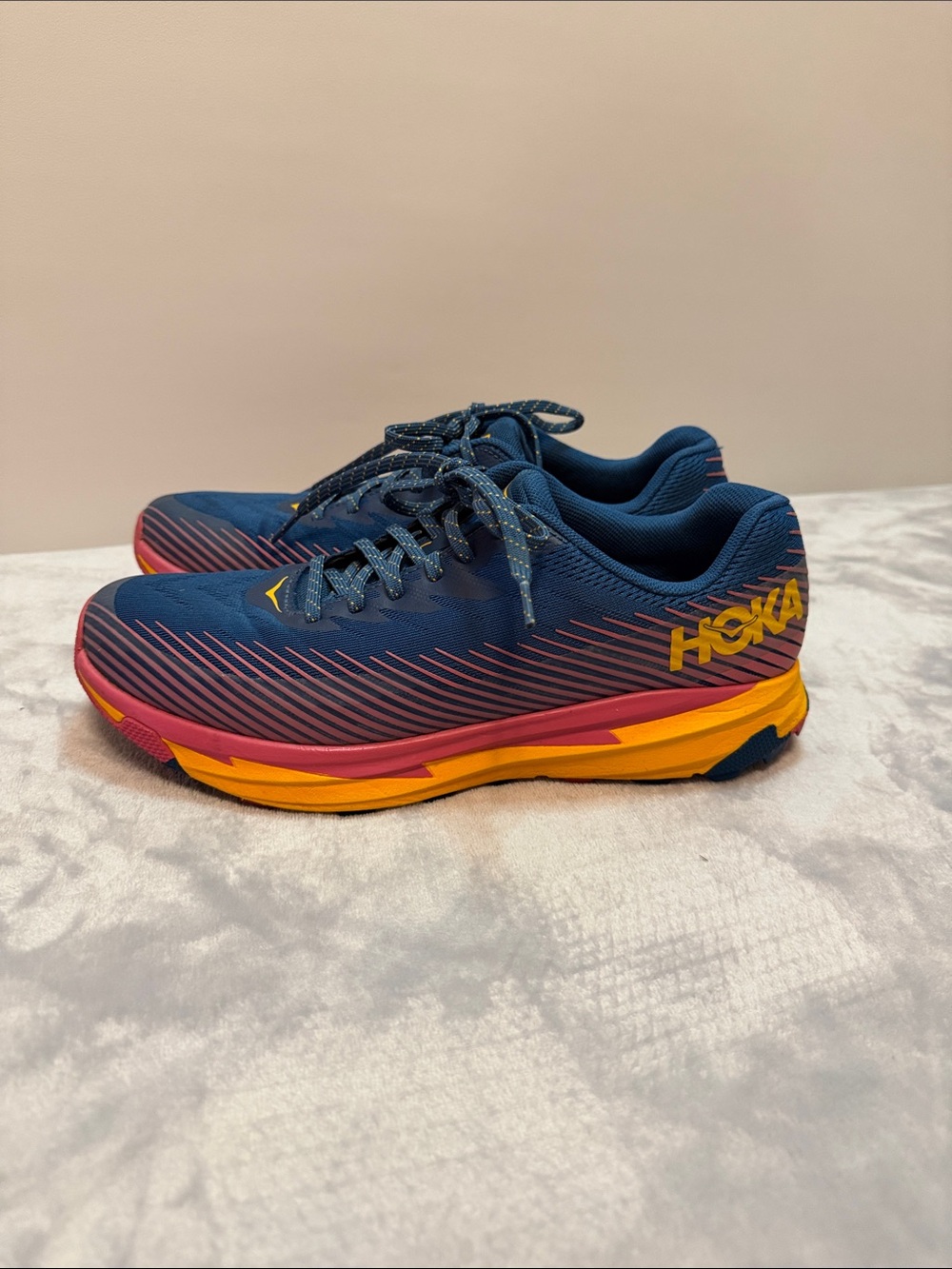 Hoka navy blue running shoes with pink and yellow sole